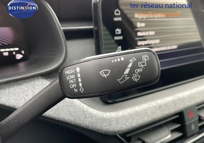Gros plan sur la manette d’essuie-glace du Skoda Kamiq 2025, intérieur gris graphite avec tableau de bord et écran tactile.