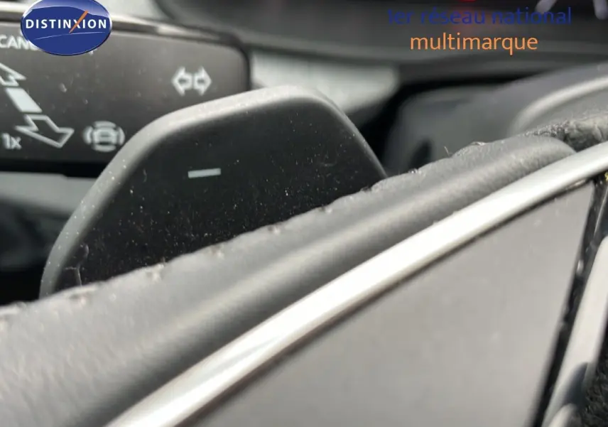 Gros plan sur la palette de changement de vitesse au volant d’un Skoda Kamiq gris graphite, intérieur cuir noir.