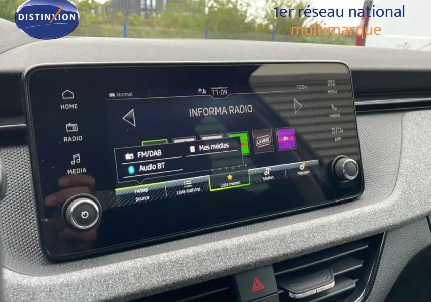Écran tactile multimédia du Skoda Kamiq 2025, affichant la radio Informa, entouré d'une finition intérieure grise texturée.