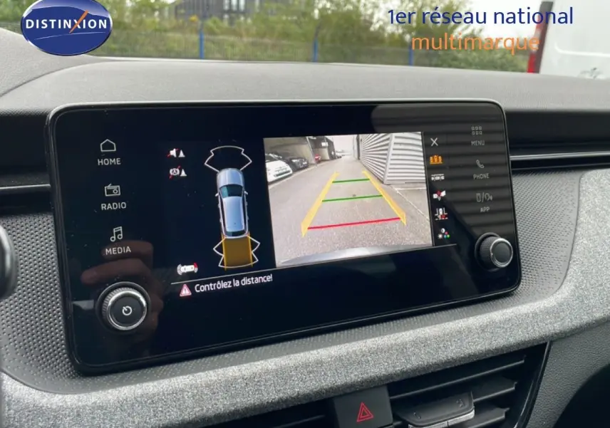 Écran central de la Skoda Kamiq 2025 montrant la caméra de recul et l’aide au stationnement, intérieur gris graphite.