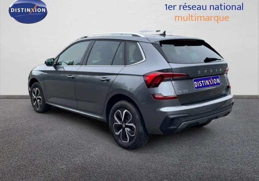 Vue 3/4 arrière droite d'un Skoda Kamiq gris graphite métal avec jantes alliage et toit blanc.