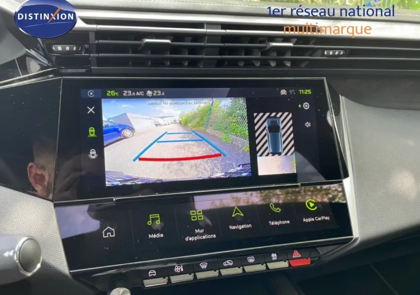 Vue rapprochée de l’écran tactile intérieur du Peugeot 308 gris Artense, affichant la caméra de recul et les options multimédia.
