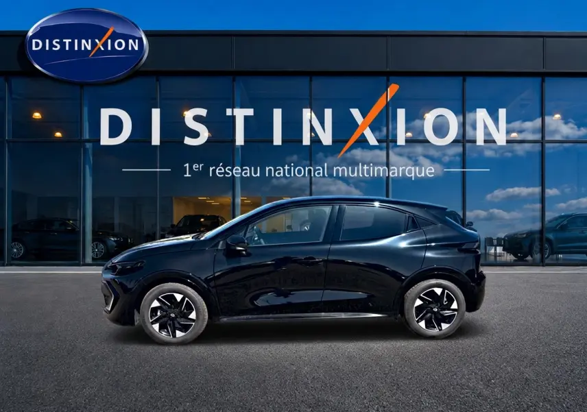 Profil droit de la Renault Clio VI noire 2026, avec jantes alliage et lignes fluides devant une vitrine Distinxion.