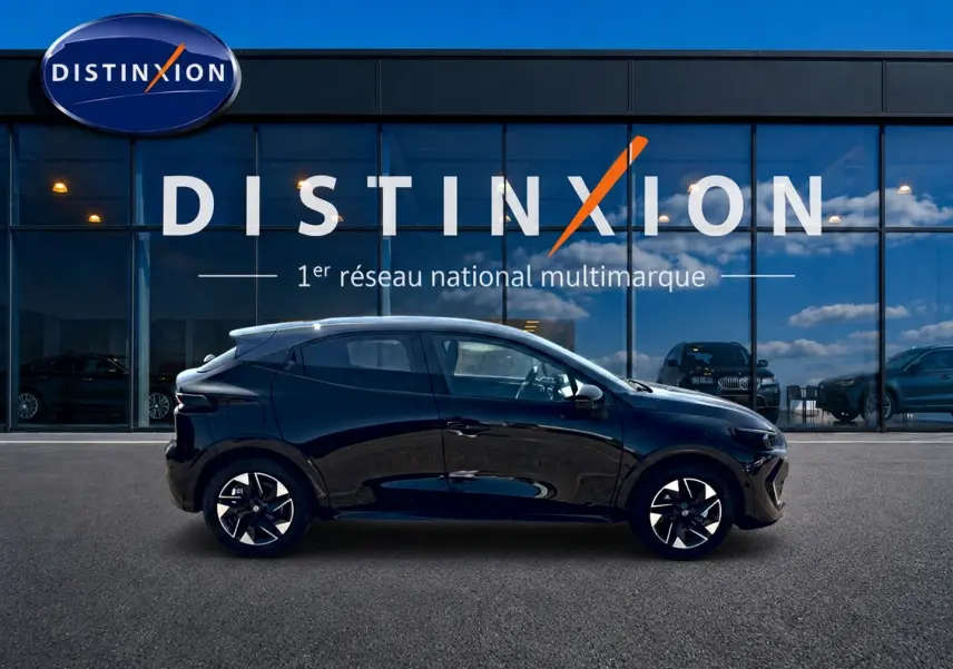 Profil latéral droit d'une Renault Clio VI noire 2026 avec jantes alliage et vitres teintées, devant une vitrine Distinxion.