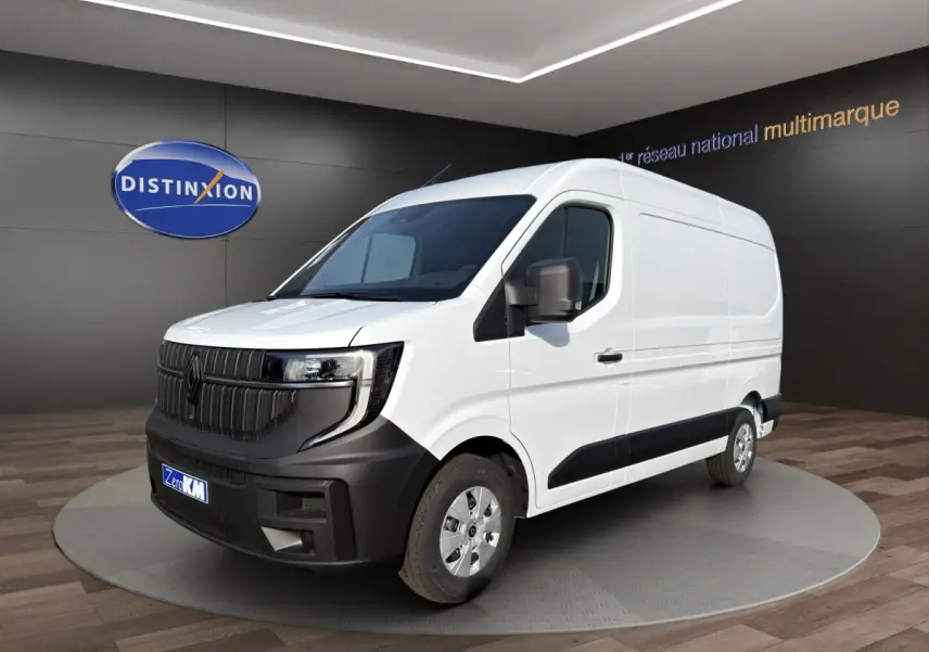 Renault Master blanc en 3/4 avant droit, avec calandre noire et pare-chocs contrastant visible en intérieur showroom.