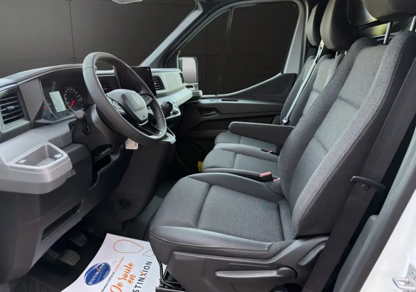 Vue intérieure côté conducteur du Renault Master 2026, montrant les sièges gris et le tableau de bord moderne.
