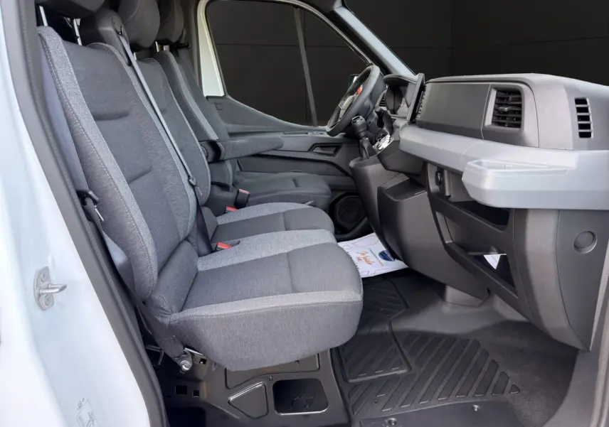 Vue intérieure côté conducteur du Renault Master blanc, montrant les sièges gris et le tableau de bord moderne.