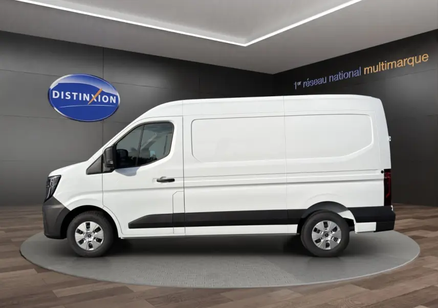 Vue de profil côté gauche d’un Renault Master blanc avec bande noire basse et jantes argentées, en showroom.