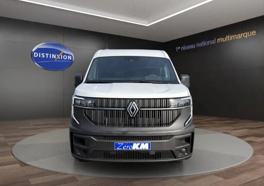 Vue avant du Renault Master blanc avec calandre noire et logo Renault proéminent en showroom.
