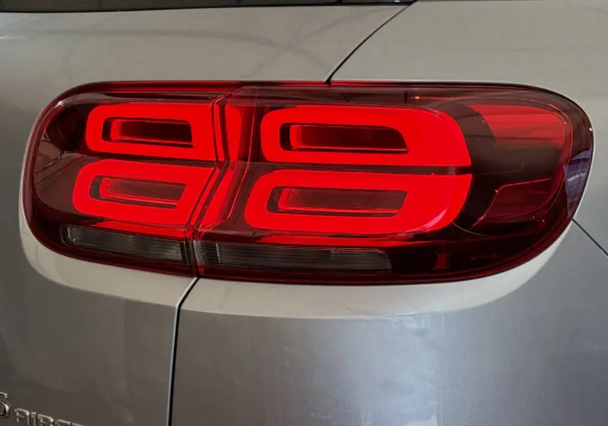 Gros plan sur le feu arrière droit rouge du Citroën C5 Aircross gris clair, soulignant son design lumineux distinctif.