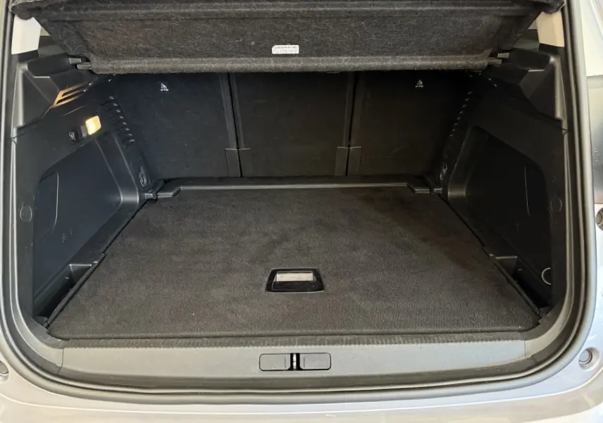 Coffre ouvert vu de l'arrière d'une Citroën C5 Aircross gris clair, espace de chargement propre et bien fini.