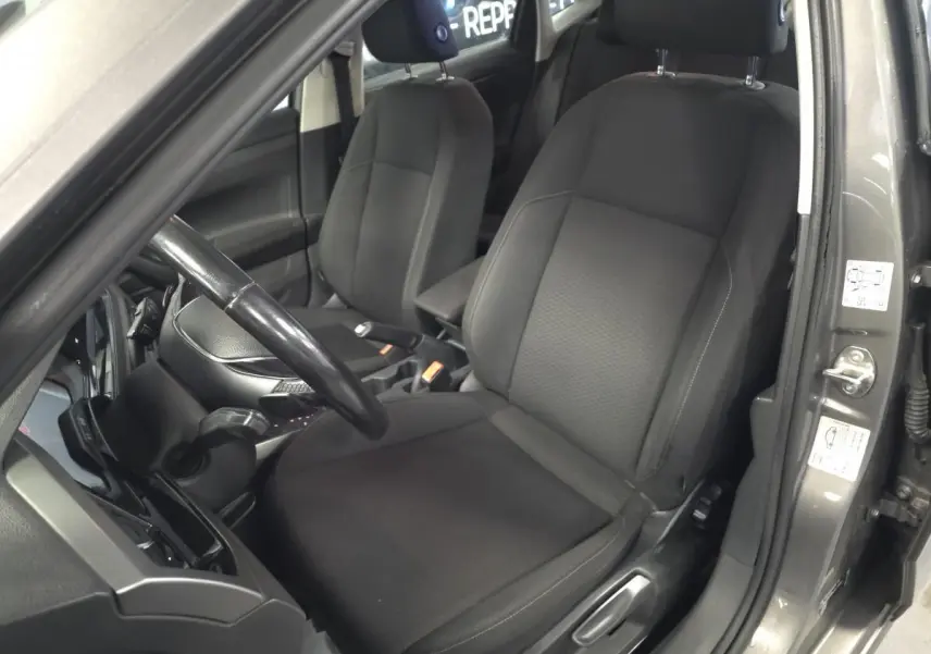 Vue intérieure côté conducteur de la Volkswagen Polo gris 2020 avec sièges tissu noirs et volant cuir multifonction.