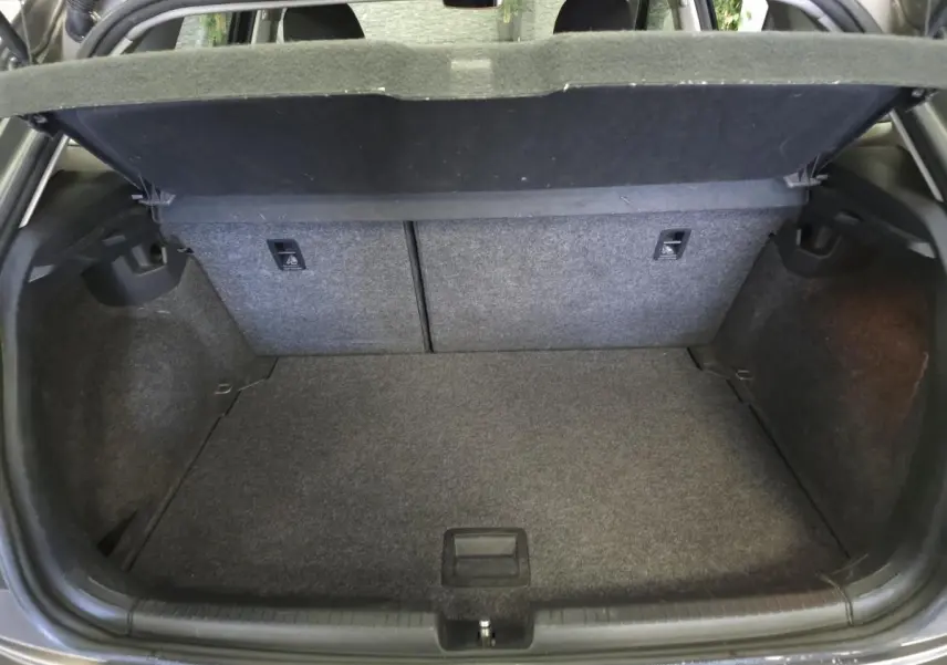 Coffre ouvert de la Volkswagen Polo gris, montrant l'espace de chargement et la tablette cache-bagages relevée.