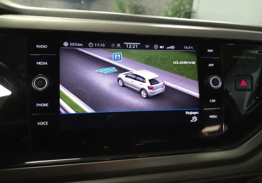 Écran de navigation affichant une voiture grise vue en 3/4 arrière sur une route virtuelle