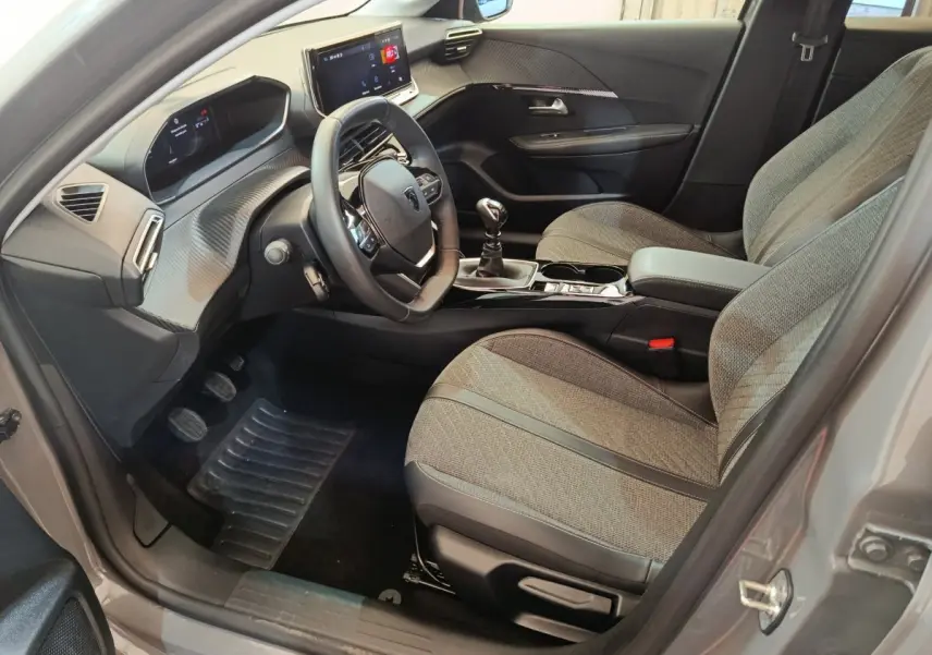Intérieur avant droit de la Peugeot 208 PureTech 100 S&S Allure gris foncé, volant cuir et écran tactile visible