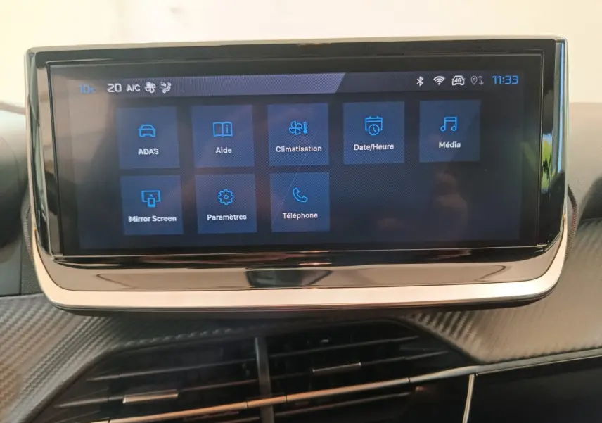 Écran tactile central de 10 pouces affichant les menus du système multimédia dans l'habitacle d'une Peugeot 208 gris foncé.