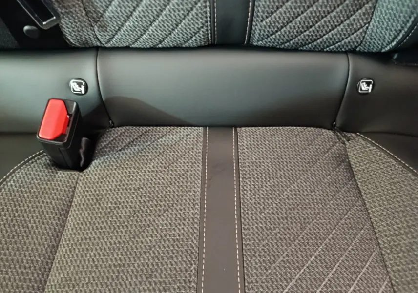 Gros plan sur la banquette arrière gris foncé de la Peugeot 208 avec ceinture de sécurité rouge et fixations Isofix visibles.
