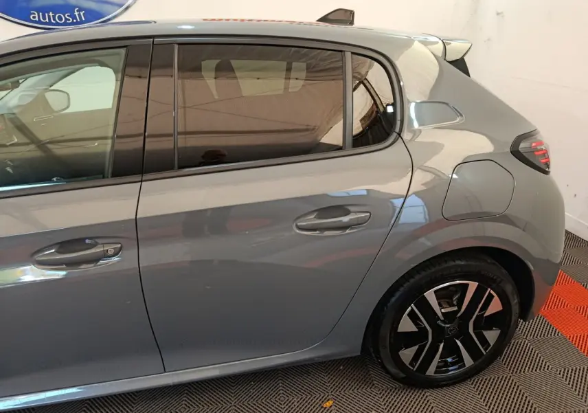 Vue latérale droite d'une Peugeot 208 gris foncé 2025 avec jante alliage et vitre arrière teintée.