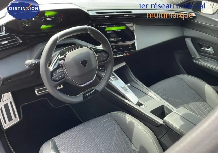 Intérieur noir de la Peugeot 308 1.2 Hybrid 145ch GT, vue côté conducteur sur le volant et la console centrale moderne.