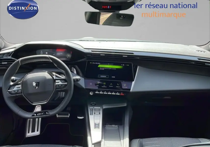 Vue intérieure avant du tableau de bord et volant noir de la Peugeot 308 1.2 Hybrid 145ch GT gris Artense métal.