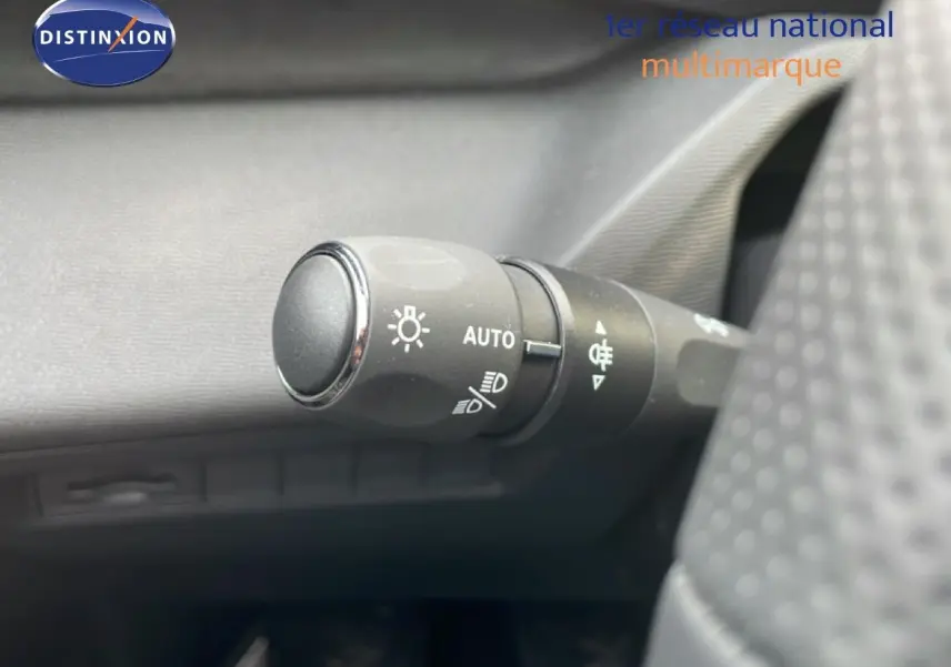 Gros plan sur la commande des phares automatiques à gauche du volant dans l’habitacle d’une Peugeot 308 gris Artense.