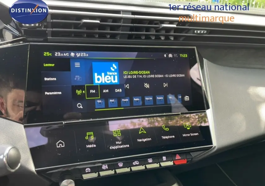 Vue intérieure du tableau de bord de la Peugeot 308 hybride 2026, avec écran tactile multimédia et commandes tactiles.