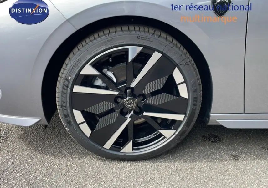 Gros plan sur la roue avant gauche d’une Peugeot 308 gris Artense métal avec jante alliage noire et argentée.