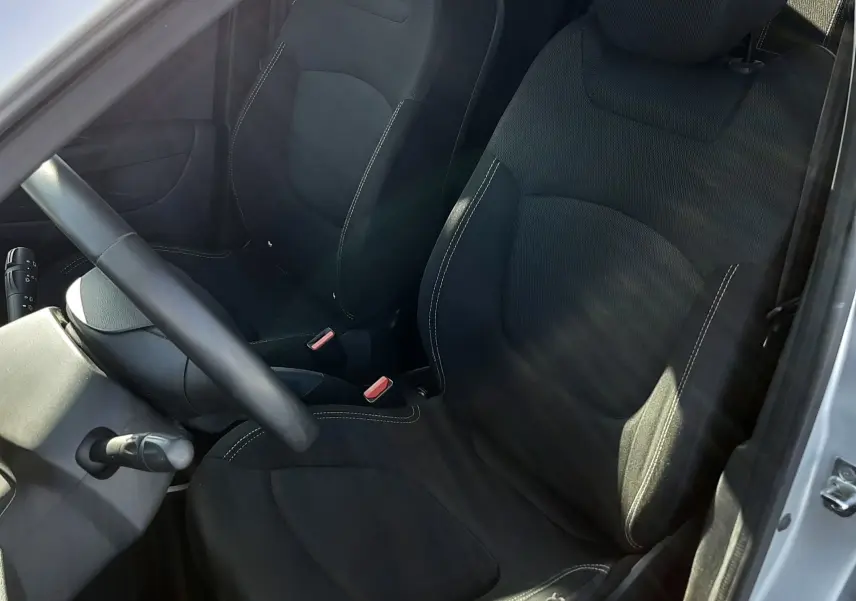 Vue intérieure côté conducteur du Renault Captur 2019, sièges tissu noir et volant multifonction.
