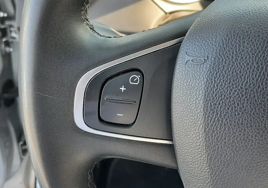 Gros plan sur les commandes de réglage des phares et du système start-stop du tableau de bord du Renault Captur gris platine.