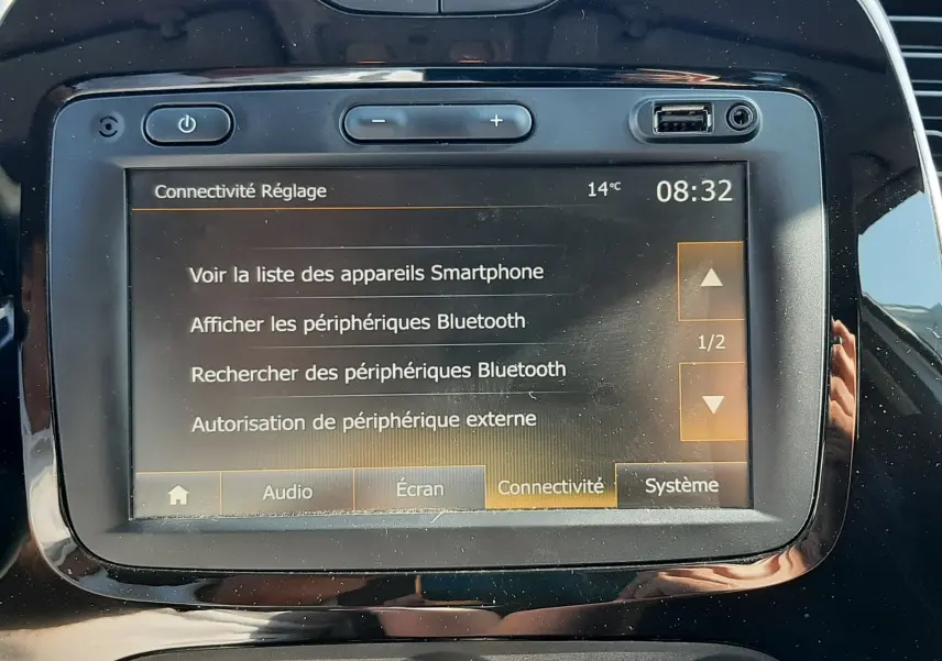 Vue rapprochée de l'écran tactile et des commandes de climatisation du tableau de bord noir du Renault Captur gris platine 2019.