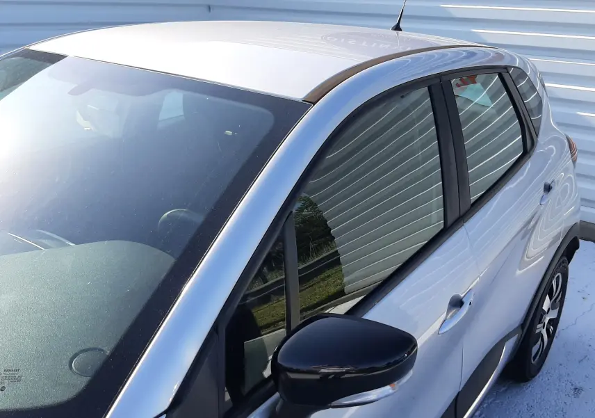 Vue 3/4 avant droit d'un Renault Captur gris platine métallisé avec rétroviseur noir et jantes alliage.