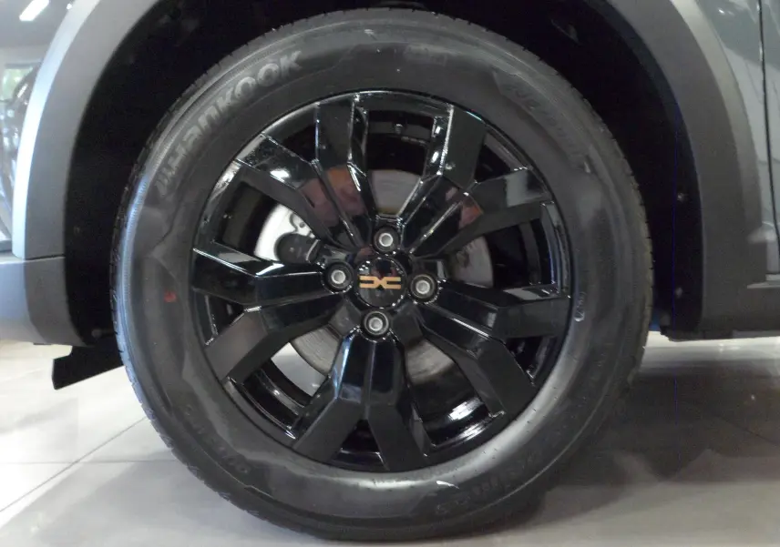 Gros plan sur la roue avant droite noire brillante du Dacia Jogger Gris Urbain 2025 version TCe 110 CH EXTREME 7PL.