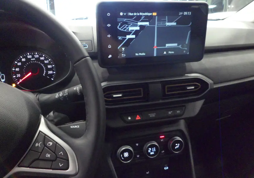 Vue intérieure du tableau de bord du Dacia Jogger gris, avec écran tactile et commandes de climatisation visibles.