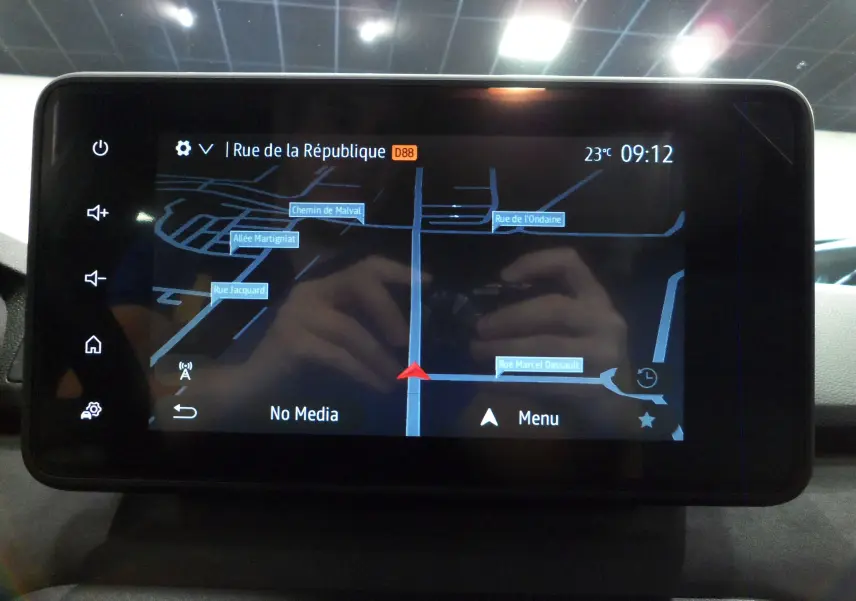 Écran tactile du GPS du Dacia Jogger 2025 affichant une carte avec navigation, dans un intérieur sombre.