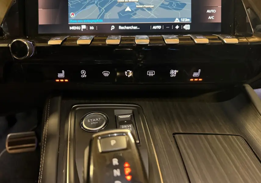 Vue rapprochée de la console centrale en bois gris avec levier de vitesses, boutons chauffants et écran tactile du Peugeot 508 gris.
