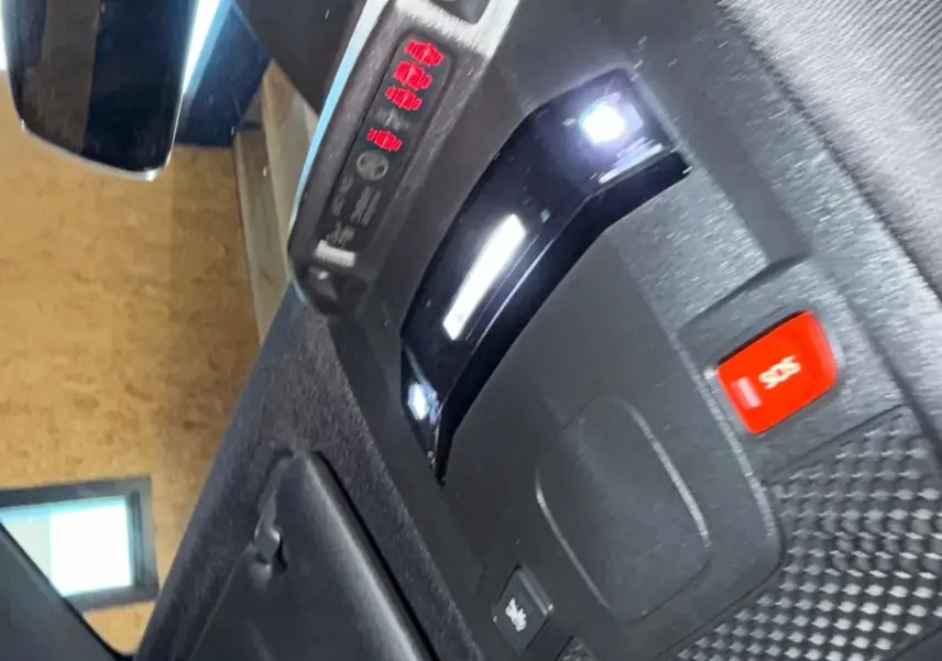 Détail du plafonnier intérieur noir avec éclairage LED et bouton SOS de la Peugeot 508 gris, vue en plongée.