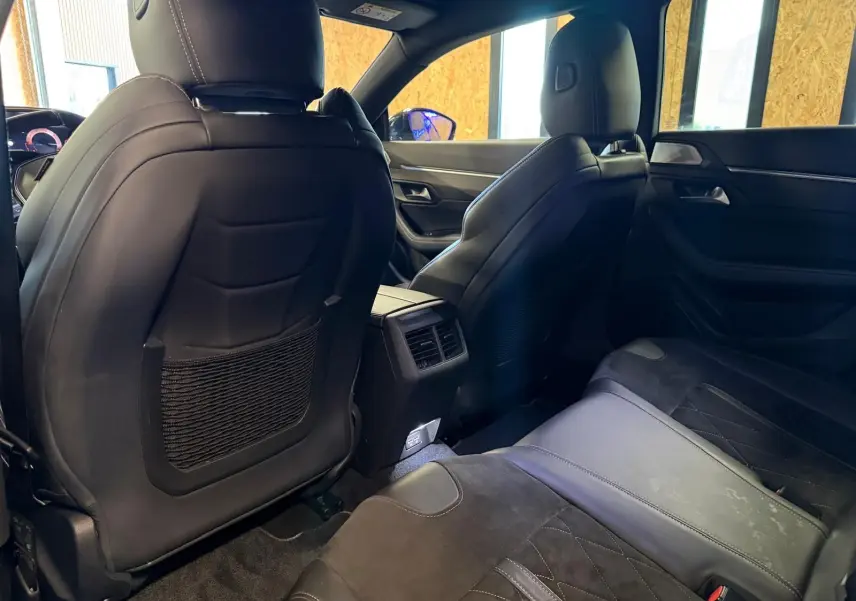 Vue intérieure arrière montrant les sièges en cuir noir et Alcantara gris du Peugeot 508 gris, avec prises USB et accoudoir central.
