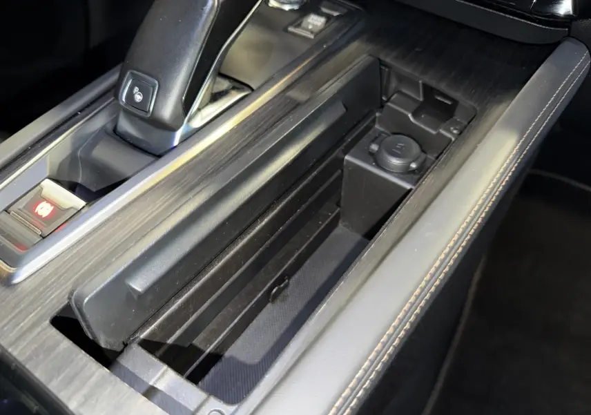 Vue rapprochée de la console centrale de la Peugeot 508 gris, avec levier de vitesse et rangement ouvert.