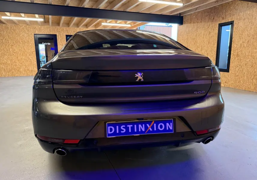 Vue arrière d'une Peugeot 508 gris métallisé avec feux arrière noirs et double sortie d'échappement en intérieur.