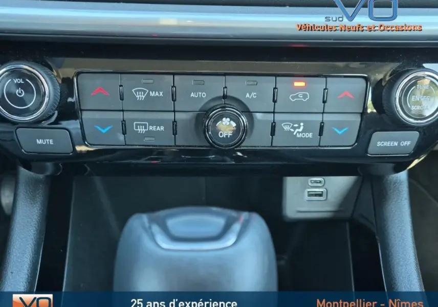 Vue rapprochée de la console centrale du Jeep Compass gris 2024, mettant en valeur les commandes de climatisation et la prise USB.