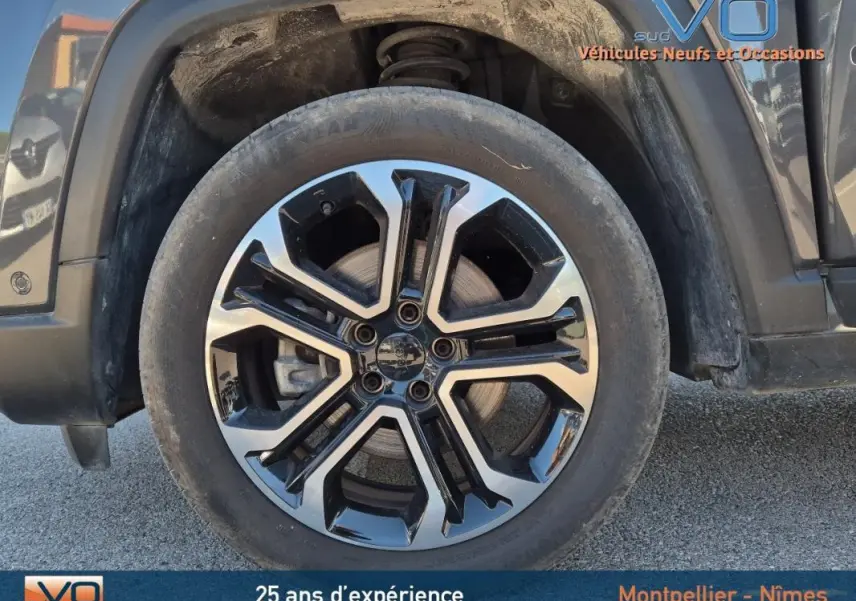 Gros plan sur la jante alliage 18 pouces noire et argentée du Jeep Compass gris 2024, côté gauche avant.