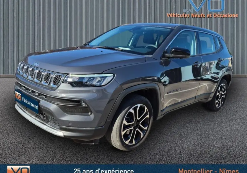 Jeep Compass gris vue 3/4 avant droit, jantes alliage 18 pouces, calandre distinctive et phares LED visibles.