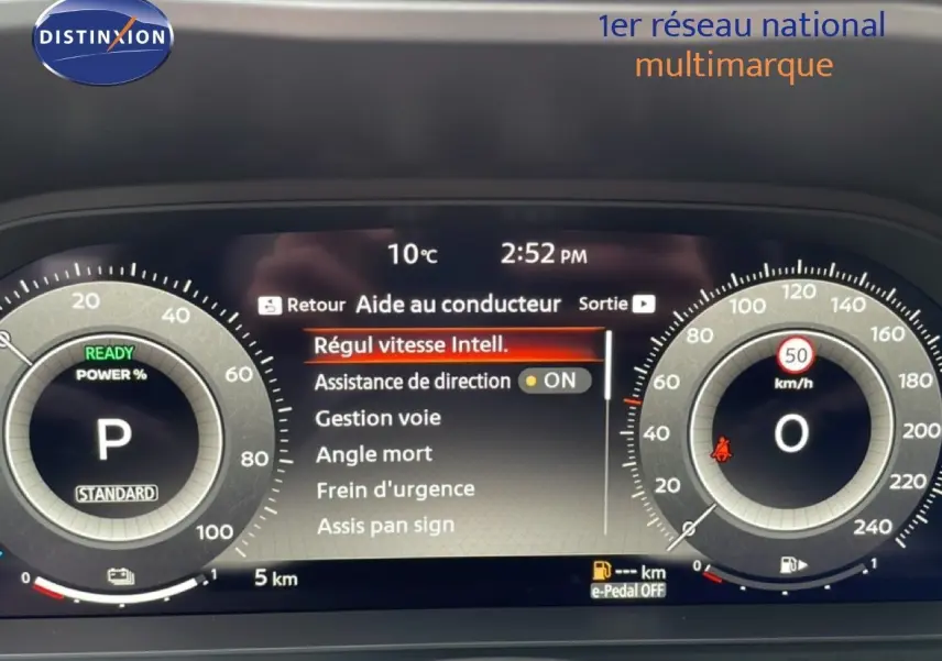 Tableau de bord numérique du Nissan Qashqai gris, affichant les aides à la conduite et la vitesse à 0 km/h.