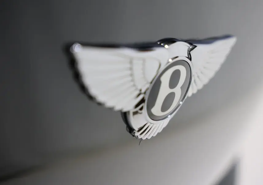 Gros plan sur l'emblème ailé Bentley chromé sur fond vert foncé du capot d'une Continental Flying Spur 2006.