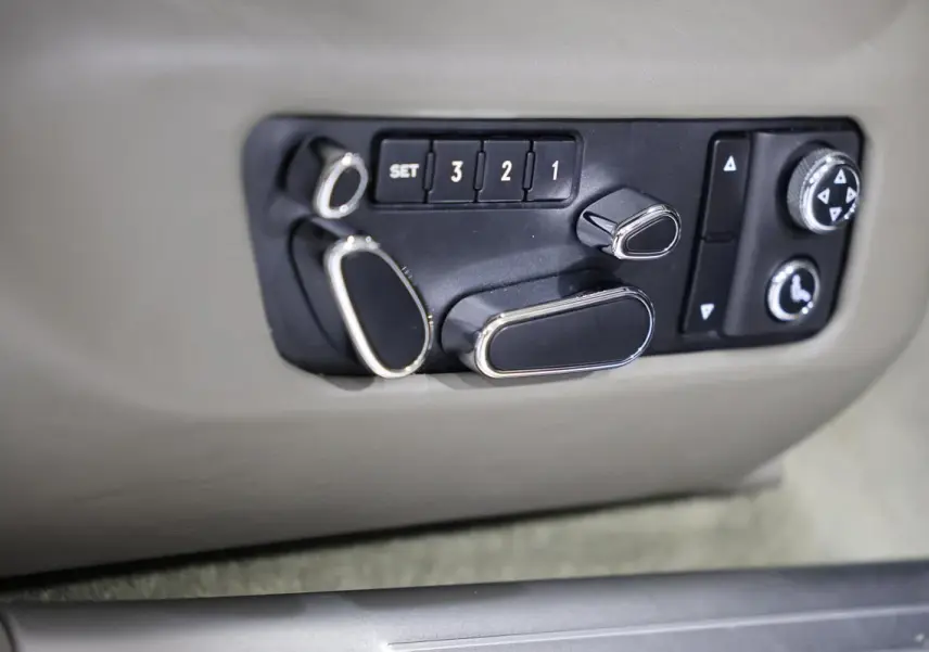 Détail des commandes de réglage électrique des sièges en cuir beige dans une Bentley Continental Flying Spur 2006.