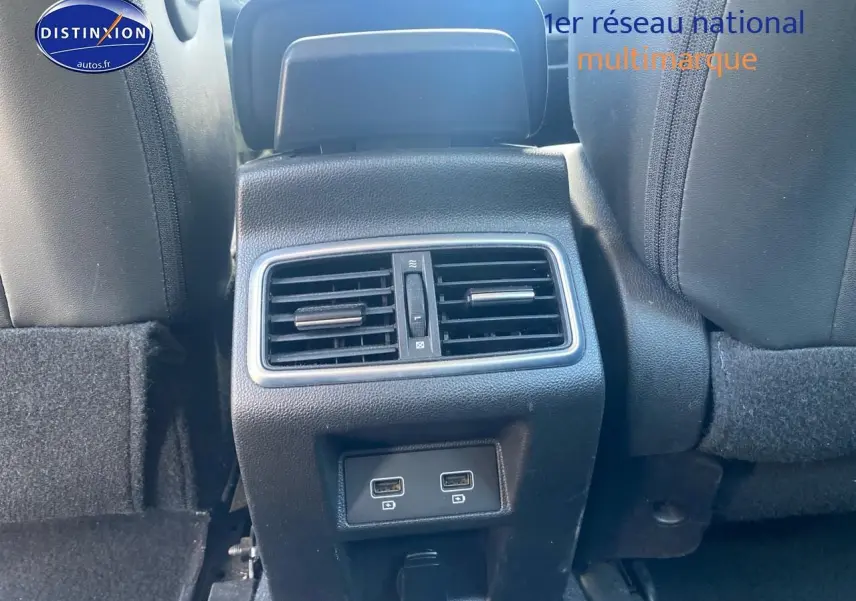 Vue rapprochée de la console arrière noire avec bouches d’aération et deux ports USB dans une Renault Mégane IV Estate bleue.