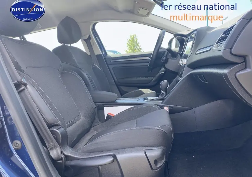 Vue intérieure côté gauche montrant les sièges avant gris foncé et la console centrale d'une Renault Mégane IV Estate bleue.