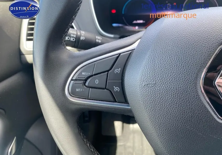 Gros plan sur le volant multifonction noir de la Renault Mégane IV Estate avec commandes de régulateur de vitesse.