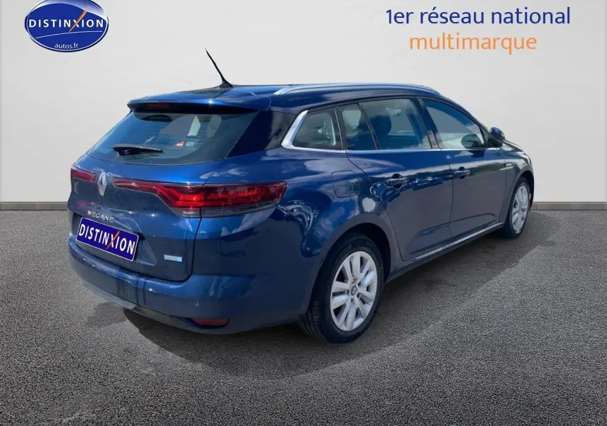 Vue 3/4 arrière droite d'une Renault Mégane IV Estate bleu métallisé avec jantes alu et vitres teintées.