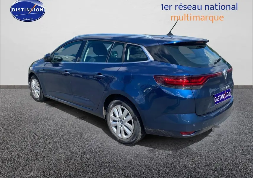 Renault Mégane IV Estate bleu, vue 3/4 arrière côté gauche, jantes alu et feux arrière LED visibles.